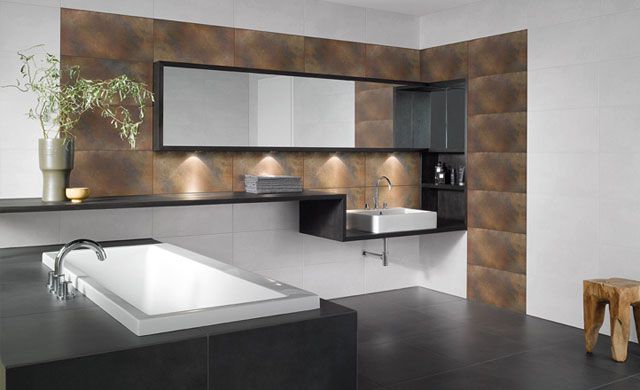 Modernes Badezimmer mit Fliesen der Serie Emotion von Agrob Buchtal in Metalloptik, großer Badewanne, Waschbecken, Spiegel.